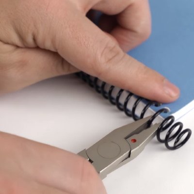 Crimping plastic coil binds with coil crimper pliers
